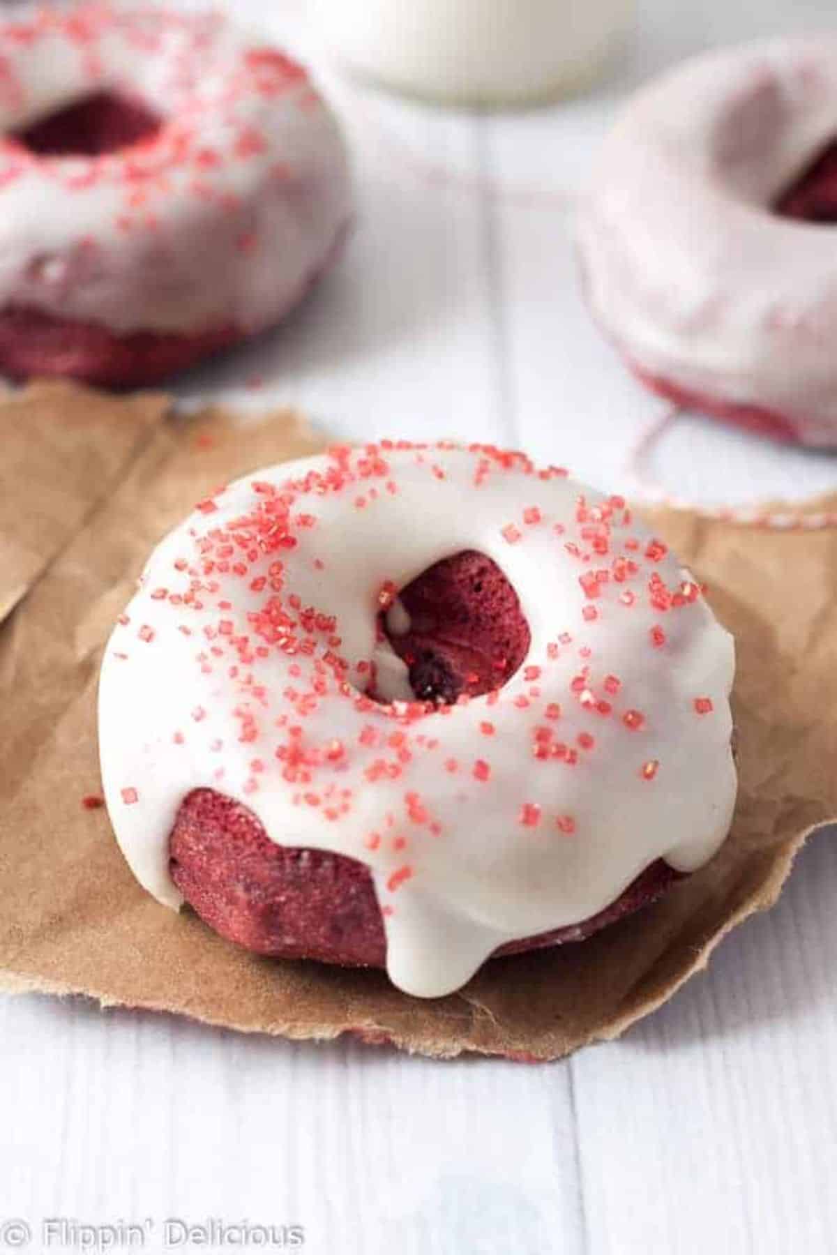 A delicious Red Velvet Doughnut on a piece of paper.