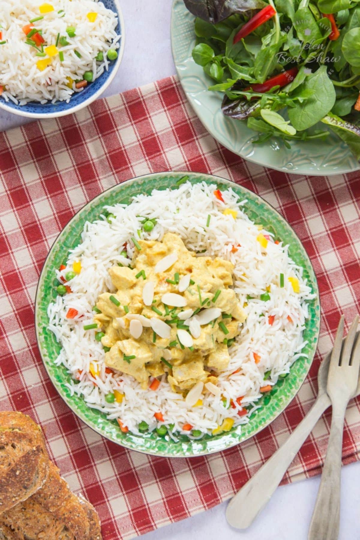 Delicious gluten-free Coronation Chicken with rice on a green plate.