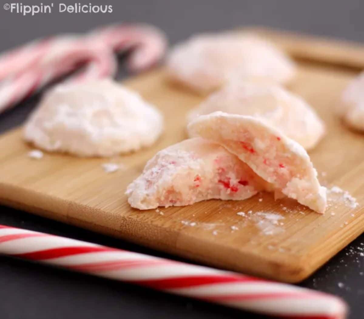 Gluten-Free Peppermint Snowball Cookies on a wooden cutting board.