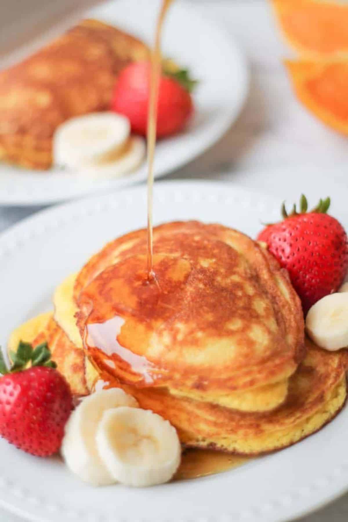 Delicious Coconut Flour Pancakes with fruits on a white plate.