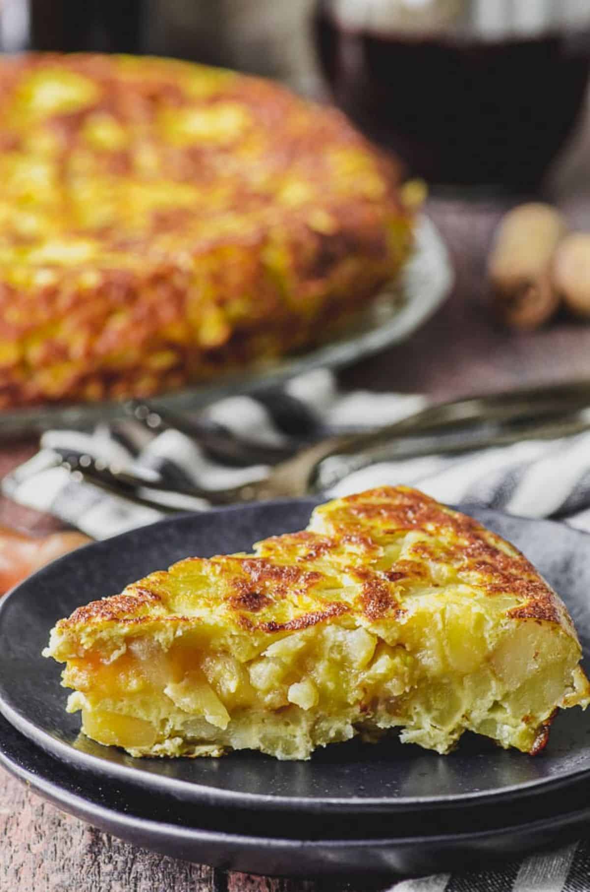 A piece of Tortilla de Patatas on a gray plate.