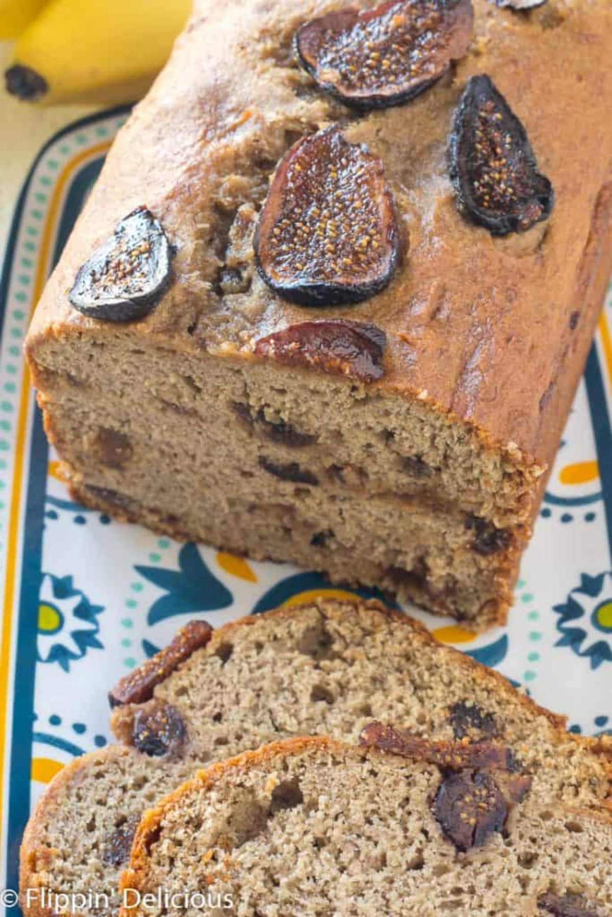 Partially sliced Banana Bread With Figs on a tray.