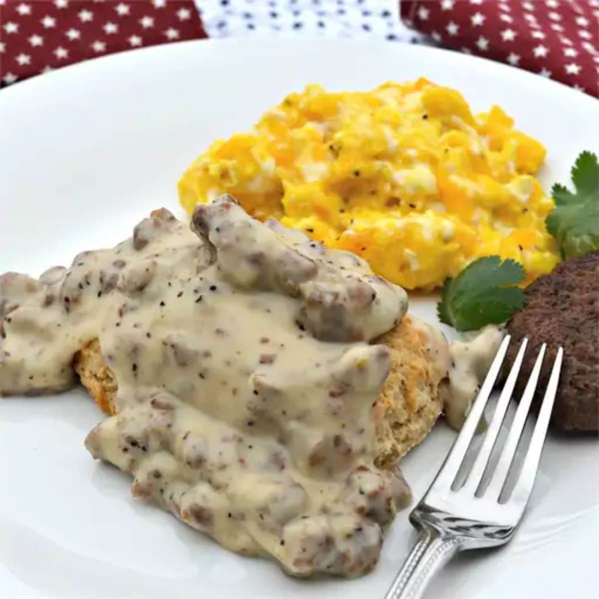 Juicy Gluten Free Sausage Gravy with a fork and scrambled eggs on a white plate.
