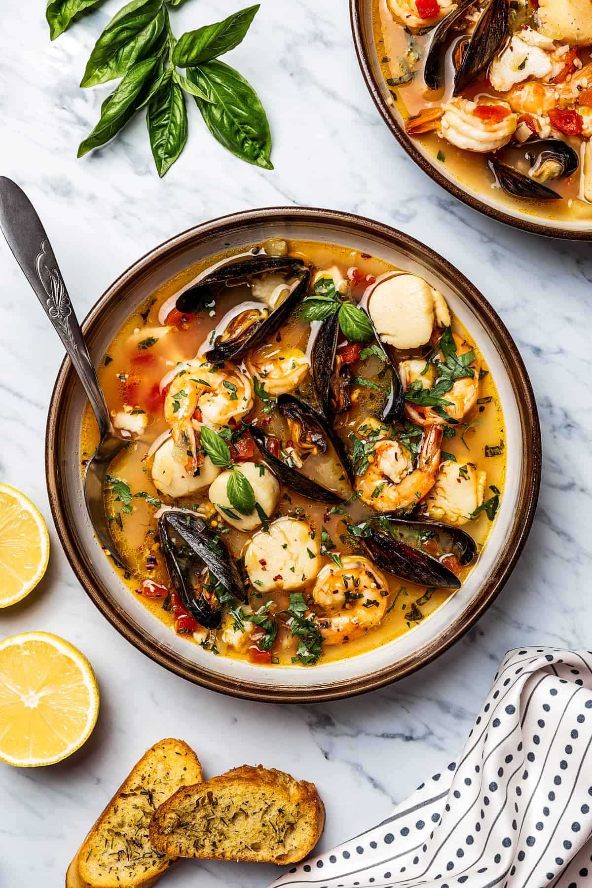 Delicious Bouillabaisse on a plate with a spoon.