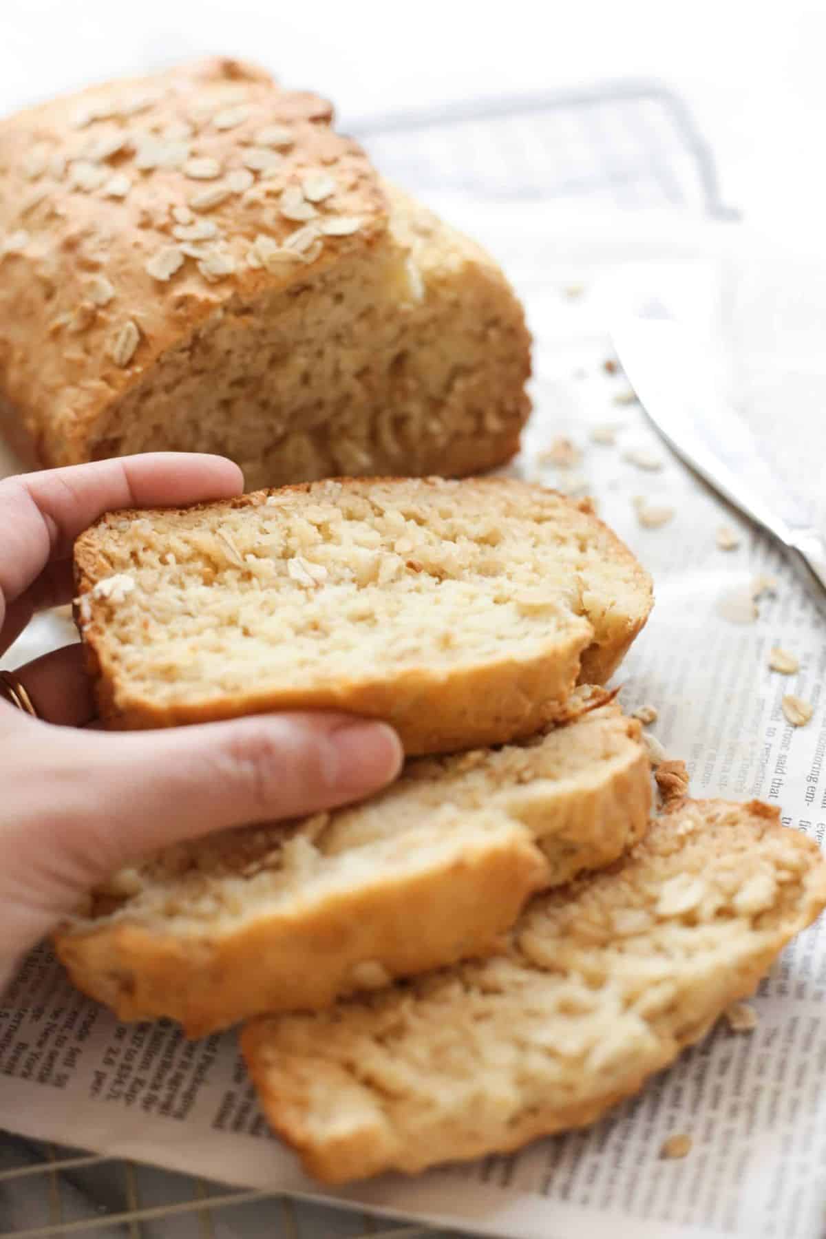 Partially sliced Honey Oat Quick Bread on newspapers.