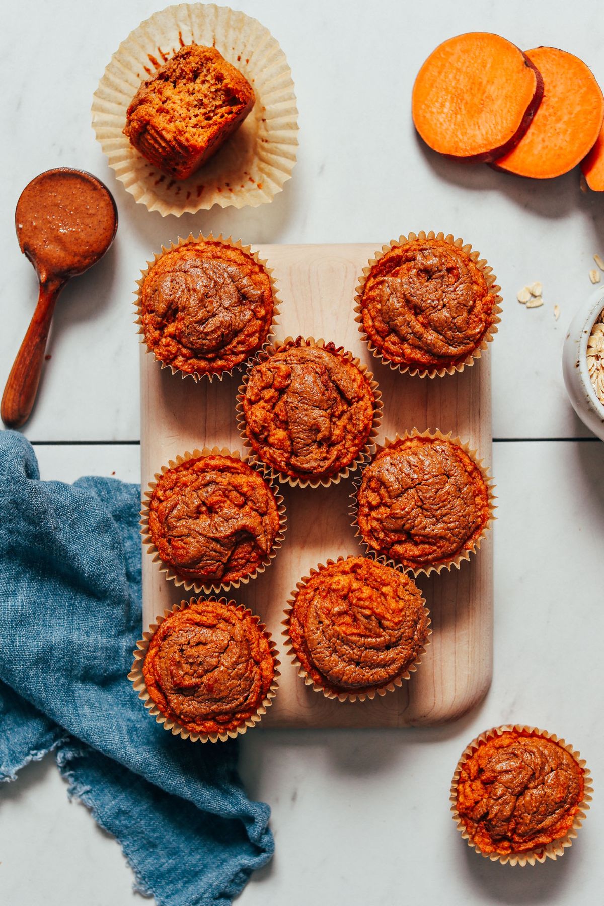 Delicious Fluffy Almond Butter Sweet Potato Muffins on a wooden cutting board.