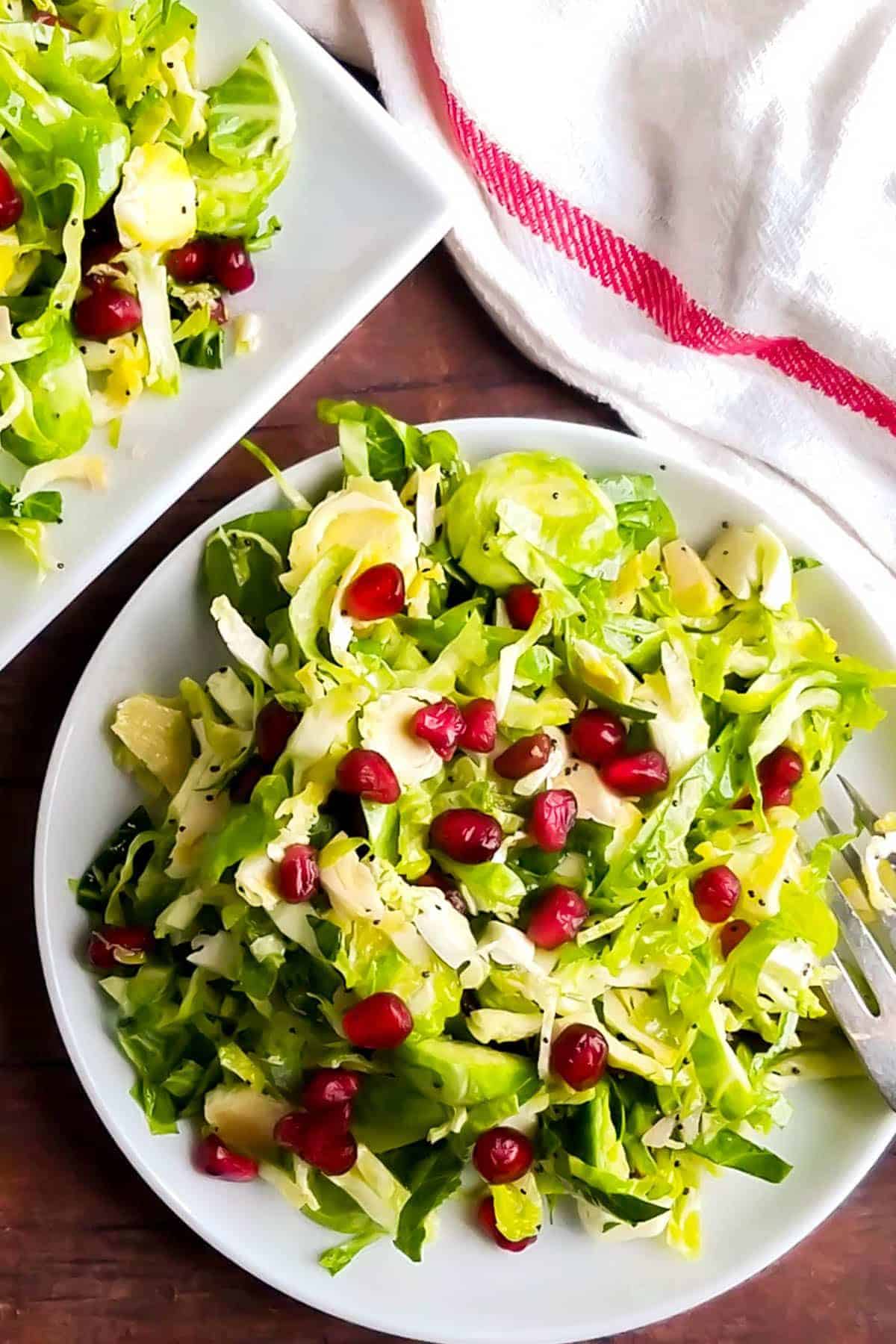 Tasty Shaved Brussels Sprout Salad on a white plate.