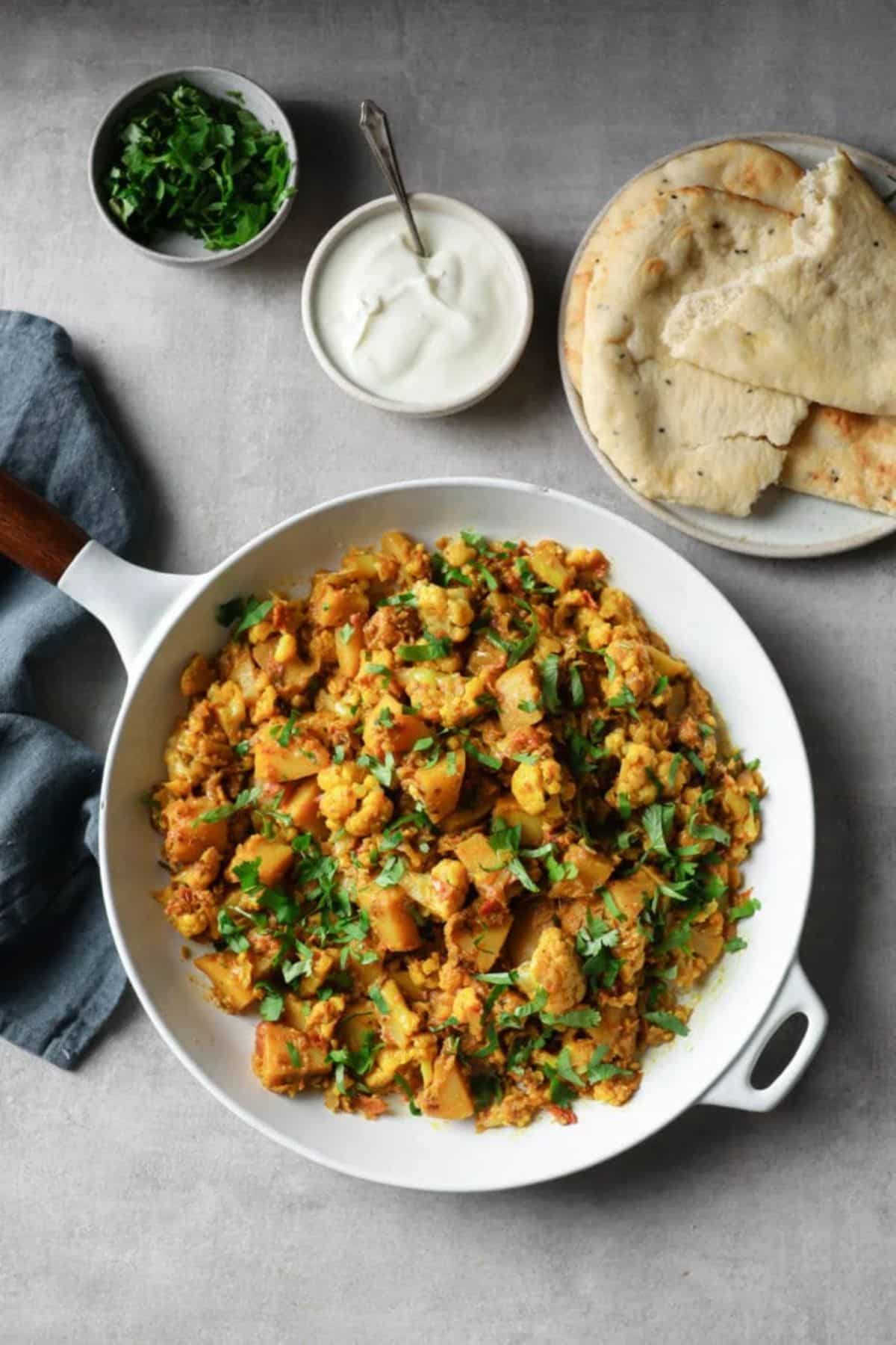 Healthy Cauliflower and Potato Curry on a white skillet.