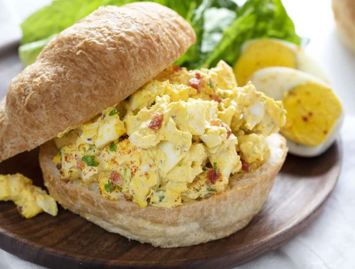 Delicious Egg Salad Sandwich on a wooden tray.