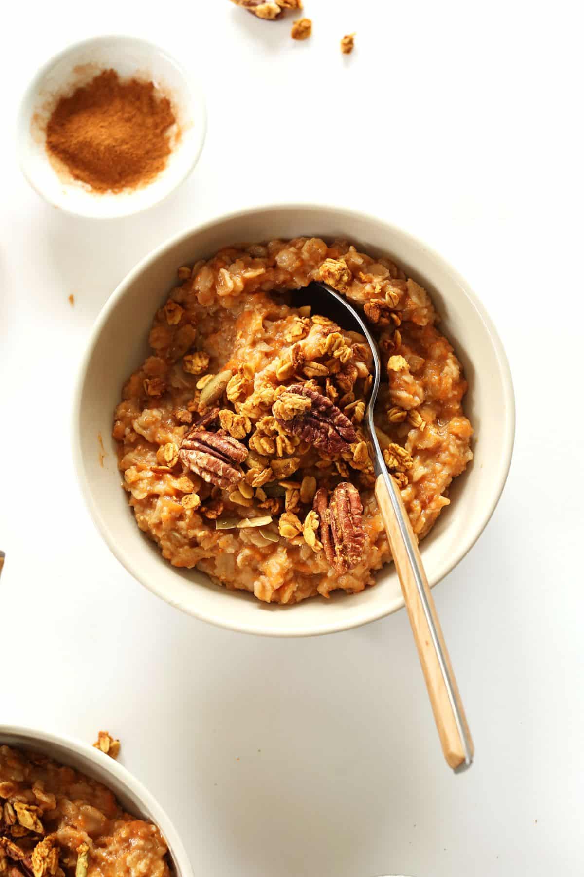 Healthy gluten-free Sweet Potato Pie Oats in a bowl with a spoon.