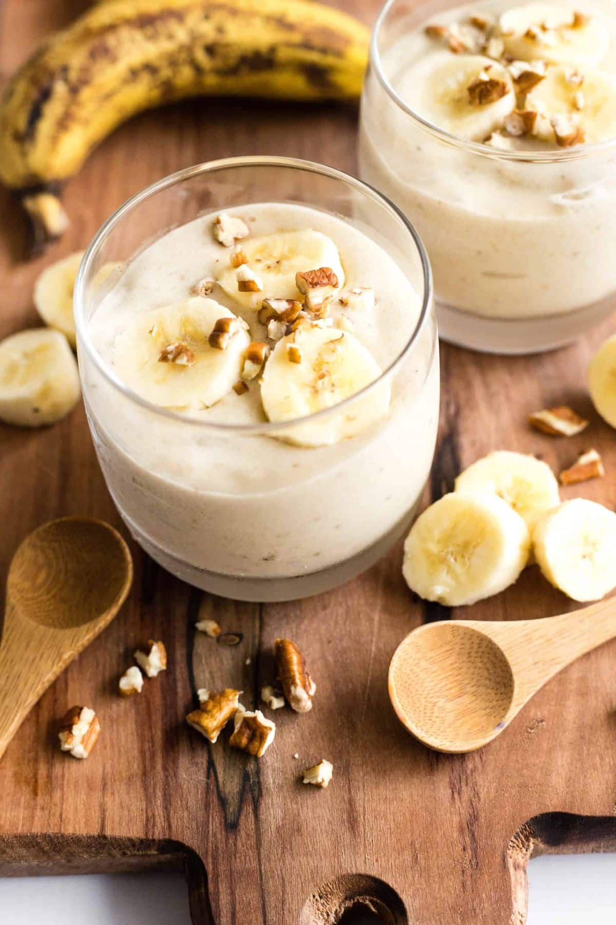 Delicious Banana Ice Cream in a glass on awooden cutting board.