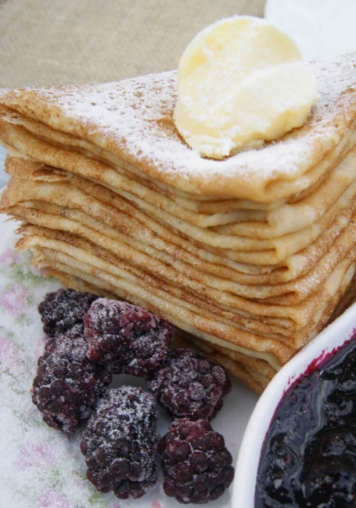 A pile of French Crepes with raspberries.