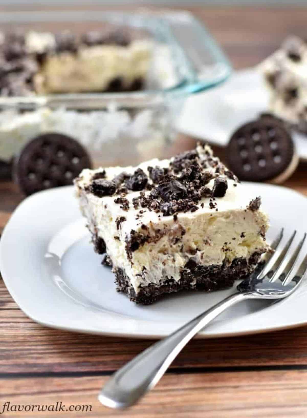 Mouth-watering No Bake Oreo Cheesecake on a white plate with a fork.