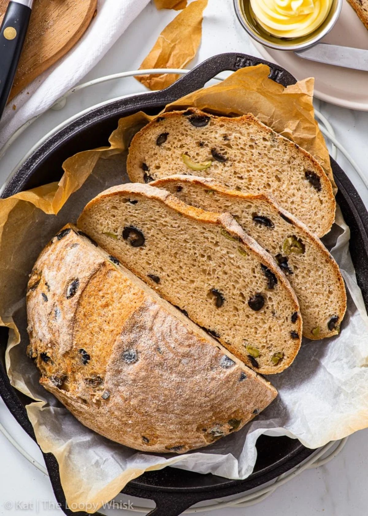 Partially sliced Olive Bread in a skillet.