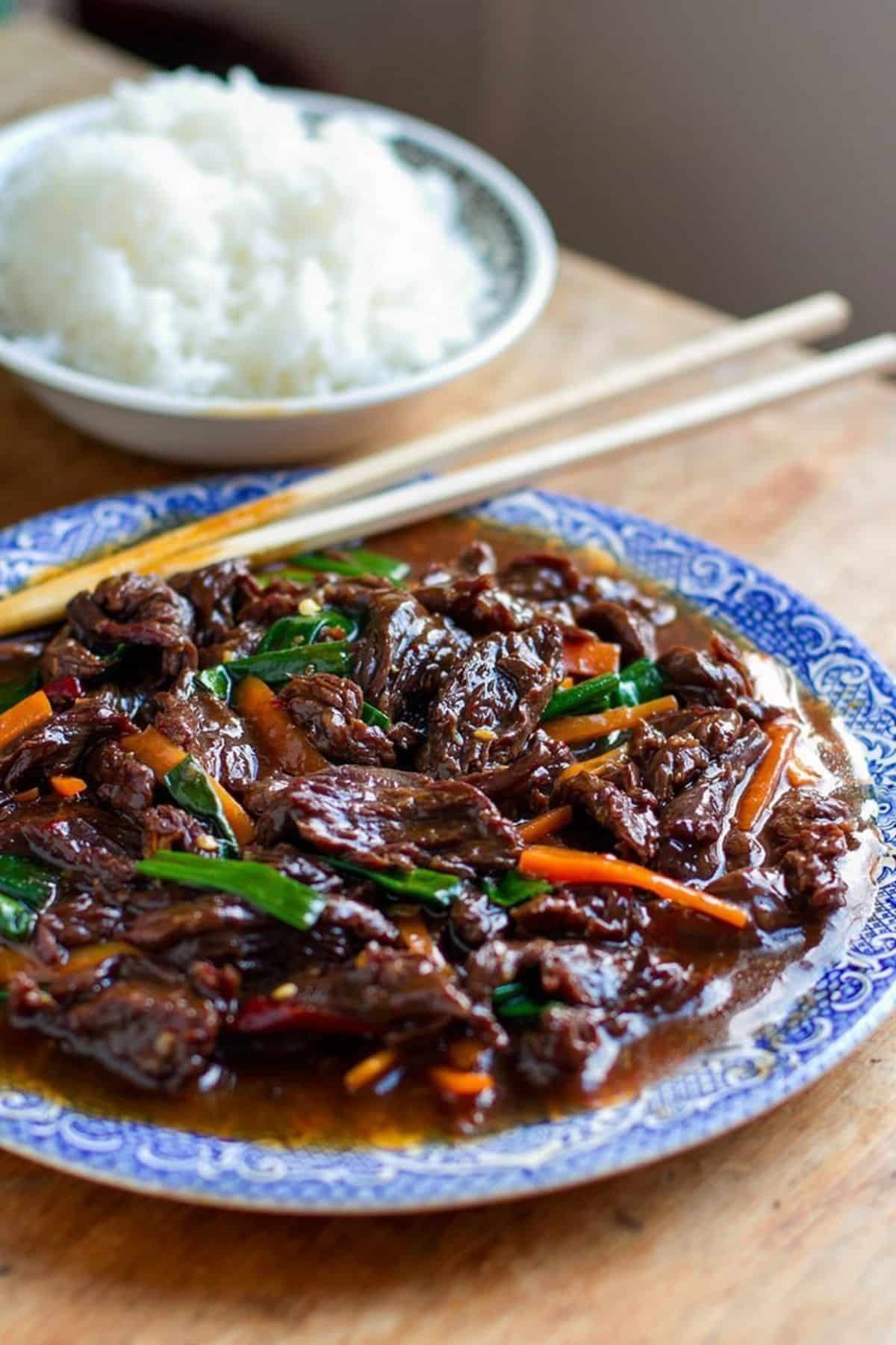 Juicy Instant Pot Mongolian Beef on a blue plate.