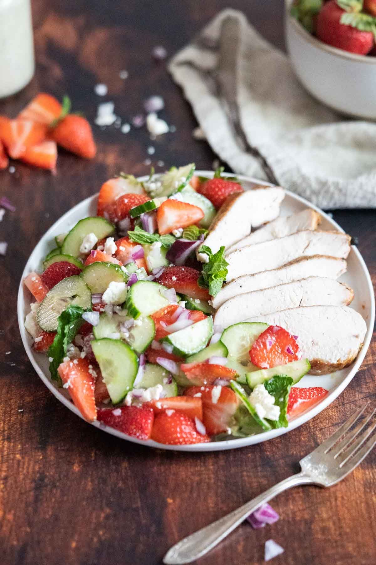Mouth-watering Strawberry Cucumber Salad on a white plate.