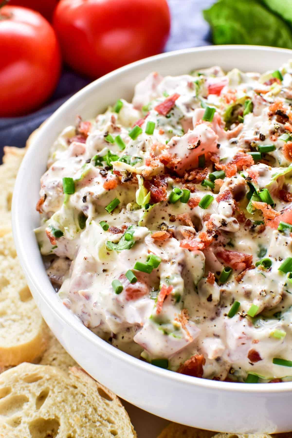 Healthy bacon, lettuce and tomato dip in a white bowl.