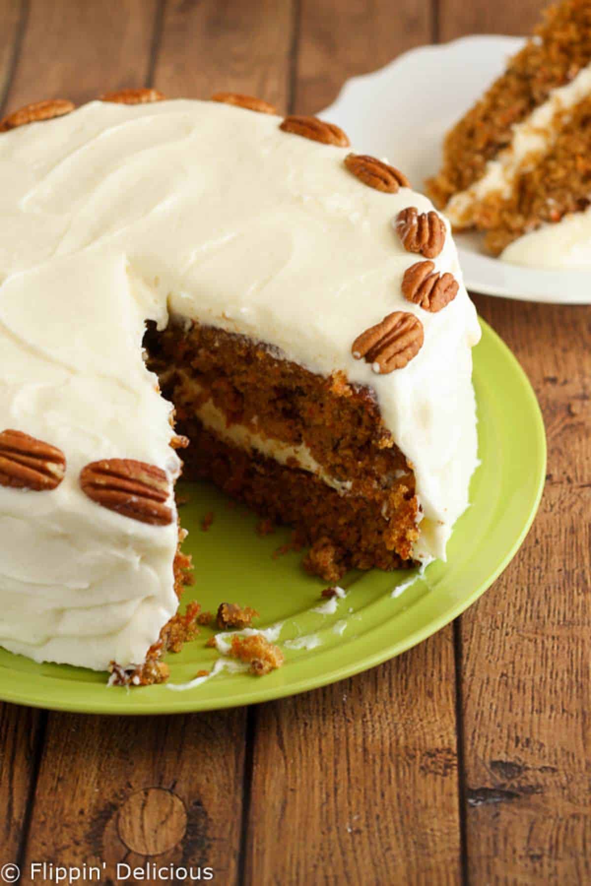 Scrumptious Carrot Cake with Buttercream Frosting and Whipped Cream on a green tray.