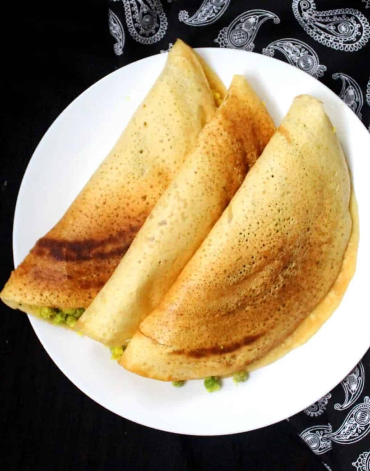 Three pieces of crunchy Gluten-Free Masala Dosa on a white plate.