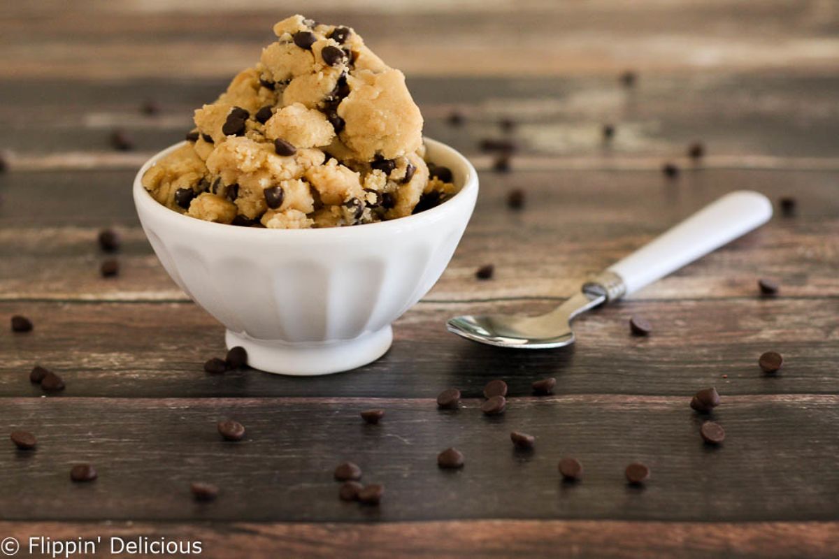 Tasty Gluten-Free Edible Cookie Dough in a white bowl on a wooden table.