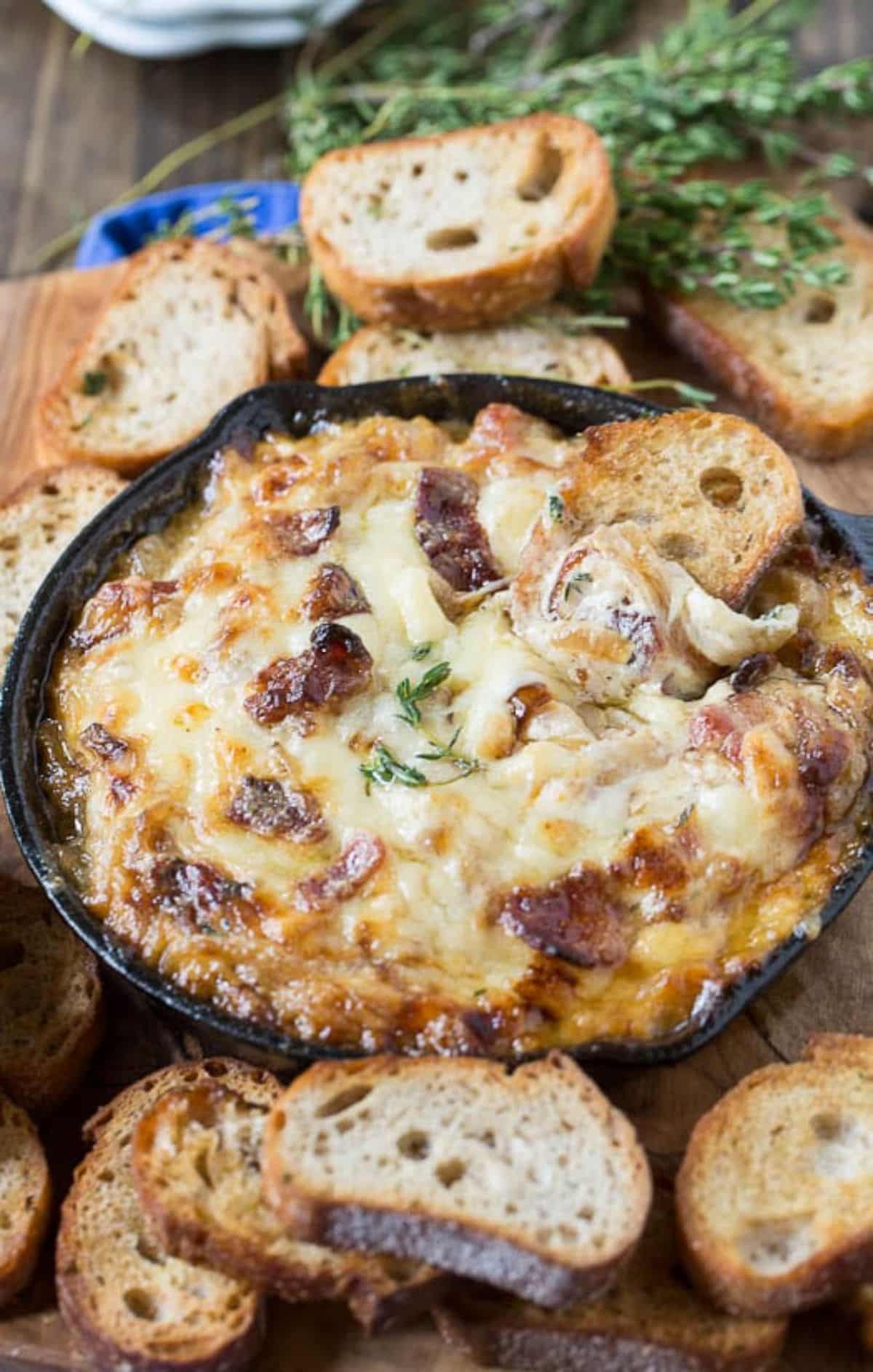 Juicy Caramelized Onion Dip with Bacon in a black skillet.