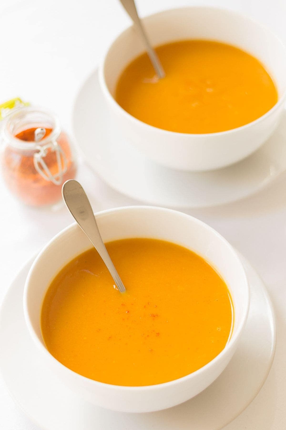 Creamy Carrot and Sweet Potato Soup in two white bowls.