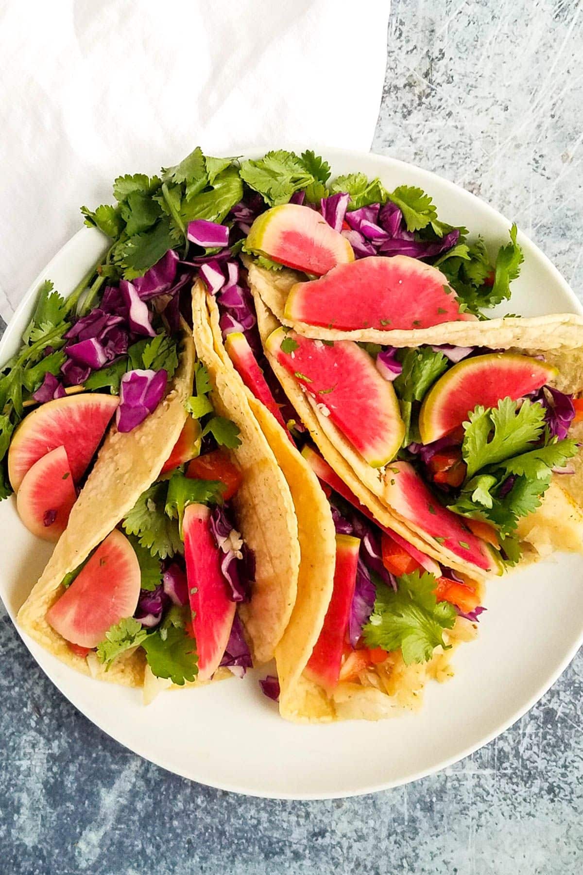 Healthy Pickled Watermelon Radishe tacos on a white plate.