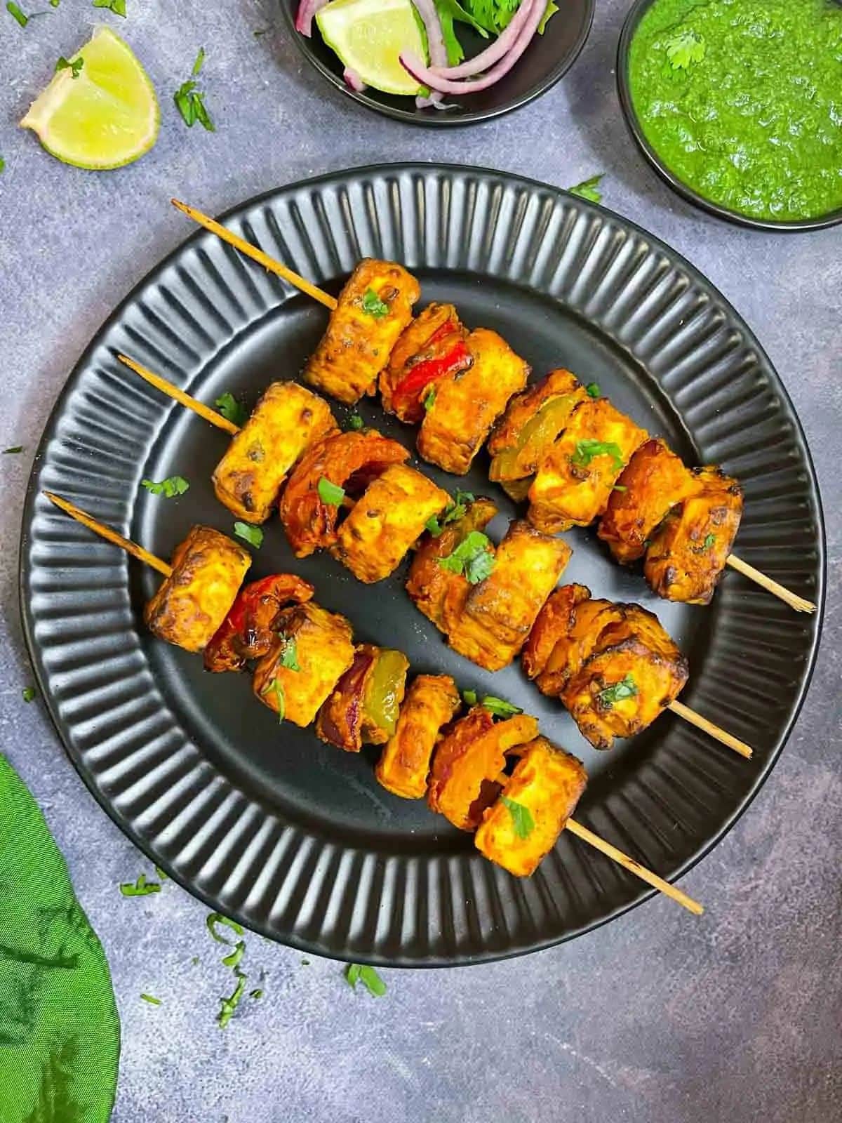 Healthy gluten-free Paneer Tikka on a black palte.