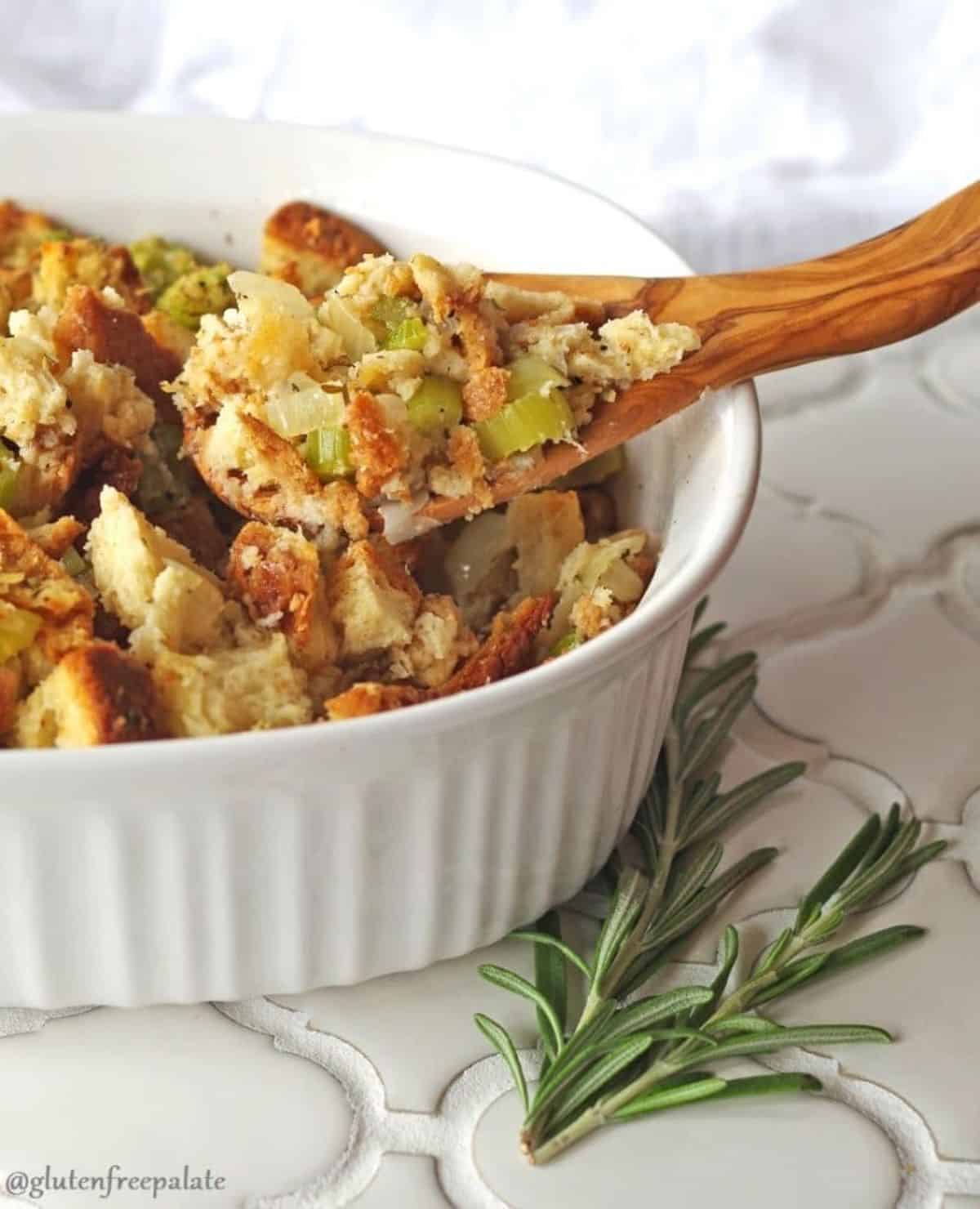 Cruncy Gluten-Free Stuffing on a wooden spatula and in a white bowl.