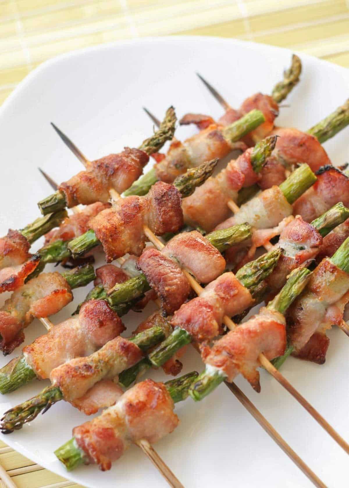 Delicious Bacon-Wrapped Asparagus on a white plate.