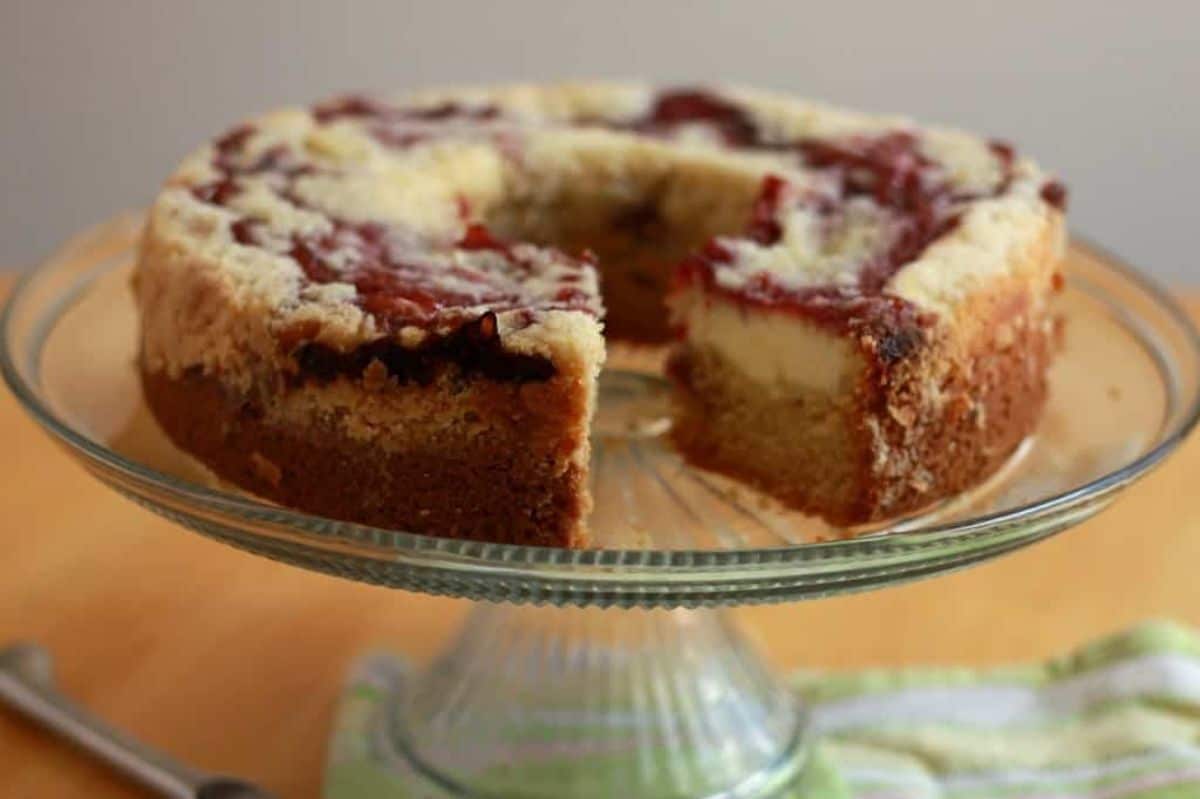 Flavorful Raspberry Cream Cheese Coffee Cake on a glass cake tray.