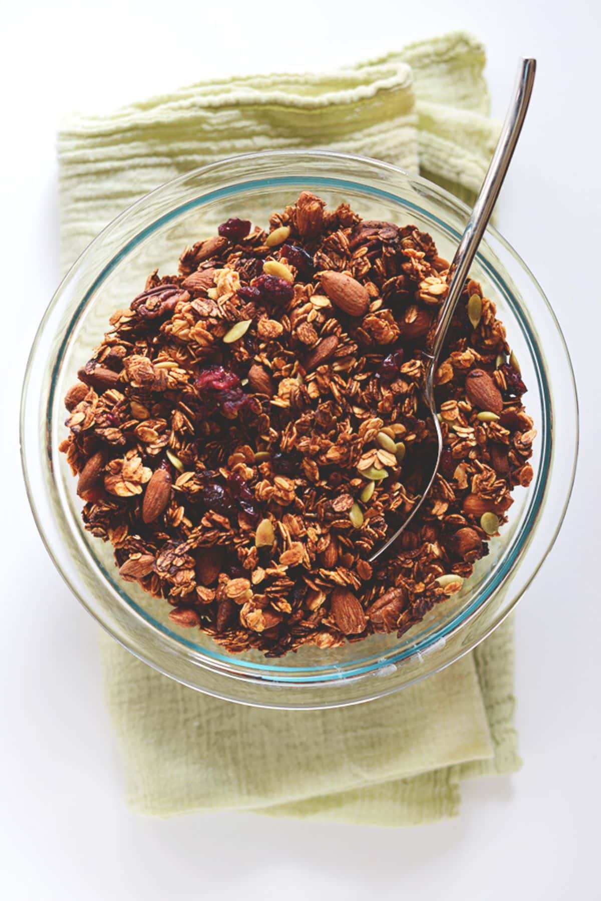 Healthy Sweet Potato Granola in a glass bowl with a spoon.