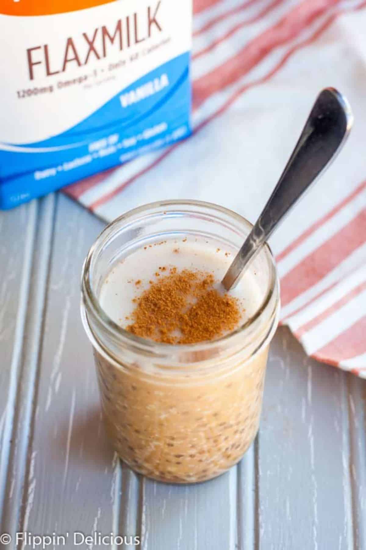 Healthy Pumpkin Pie Overnight Oats in a glass jar with a spoon.