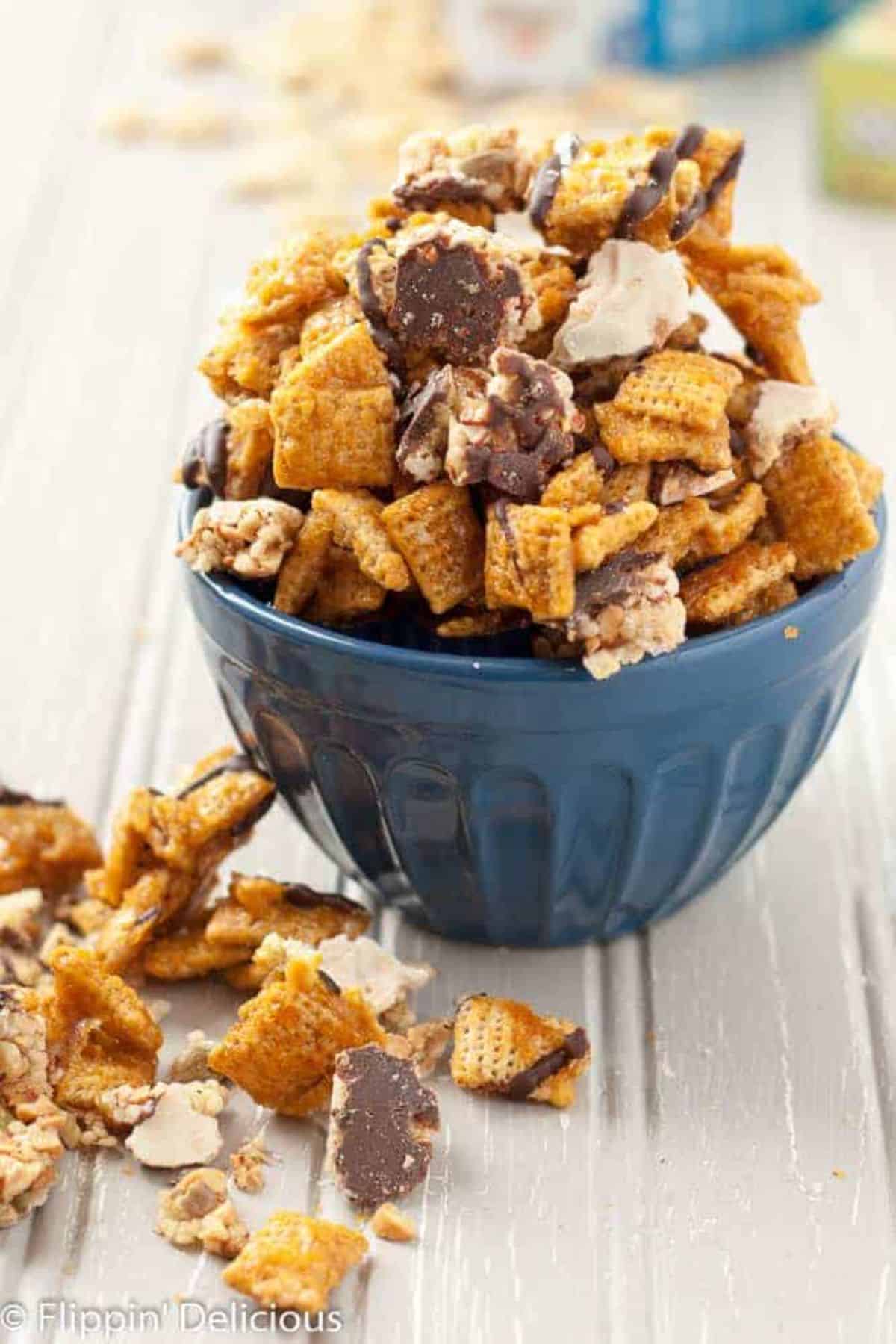 Crunchy Salted Caramel Chocolate Chex Mix in a blue bowl.