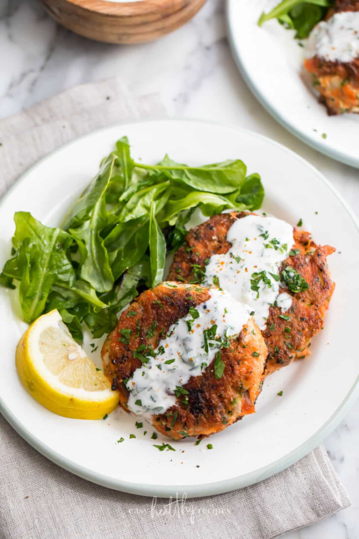 Mouth-watering Salmon Patties and Lemon Garlic Sauce on a white plate.