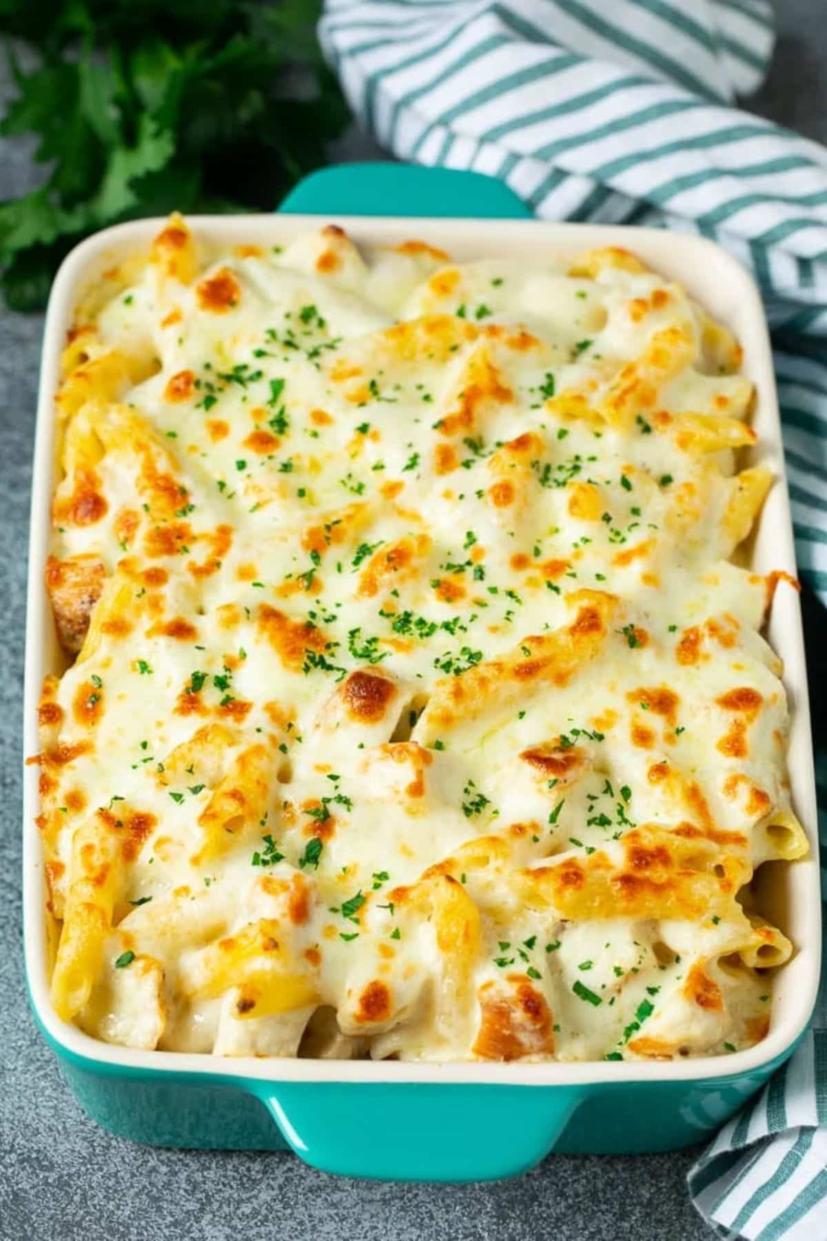 Juicy Chicken Alfredo Pasta Bake in a white casserole.