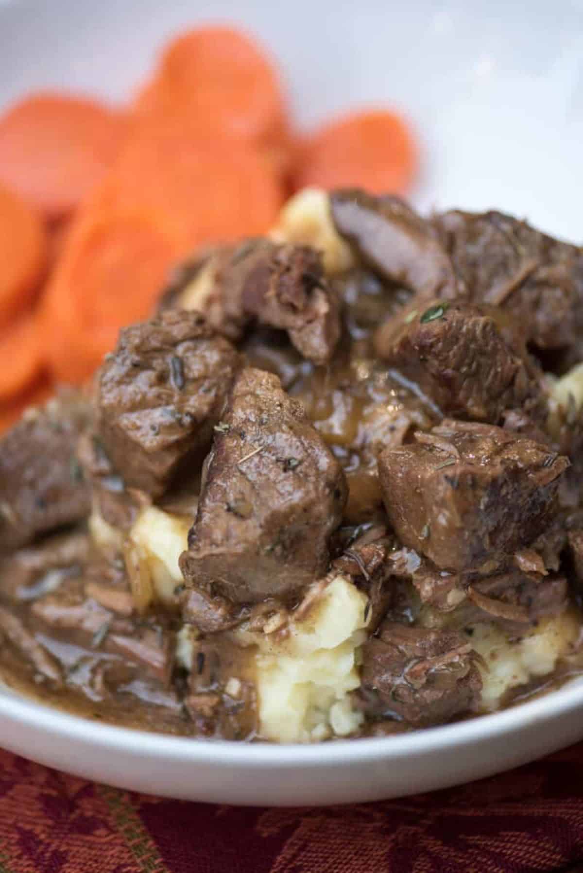 Juicy Slow Cooker Beef Tips with Gravy on a white plate.