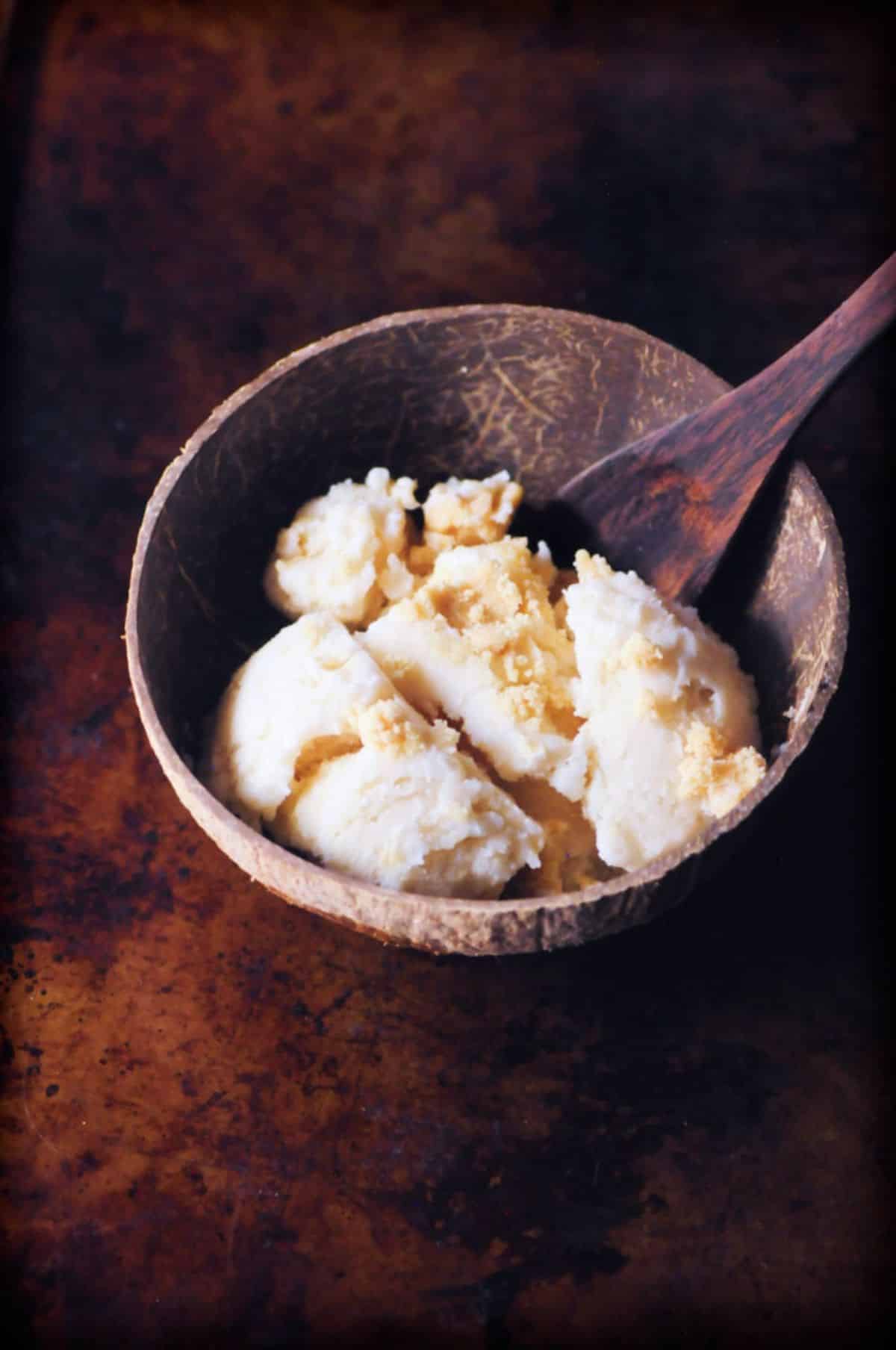 Delicious Double Coconut Caramel Cookie Dough Ice Cream in a wooden bowl with a wooden spoon.