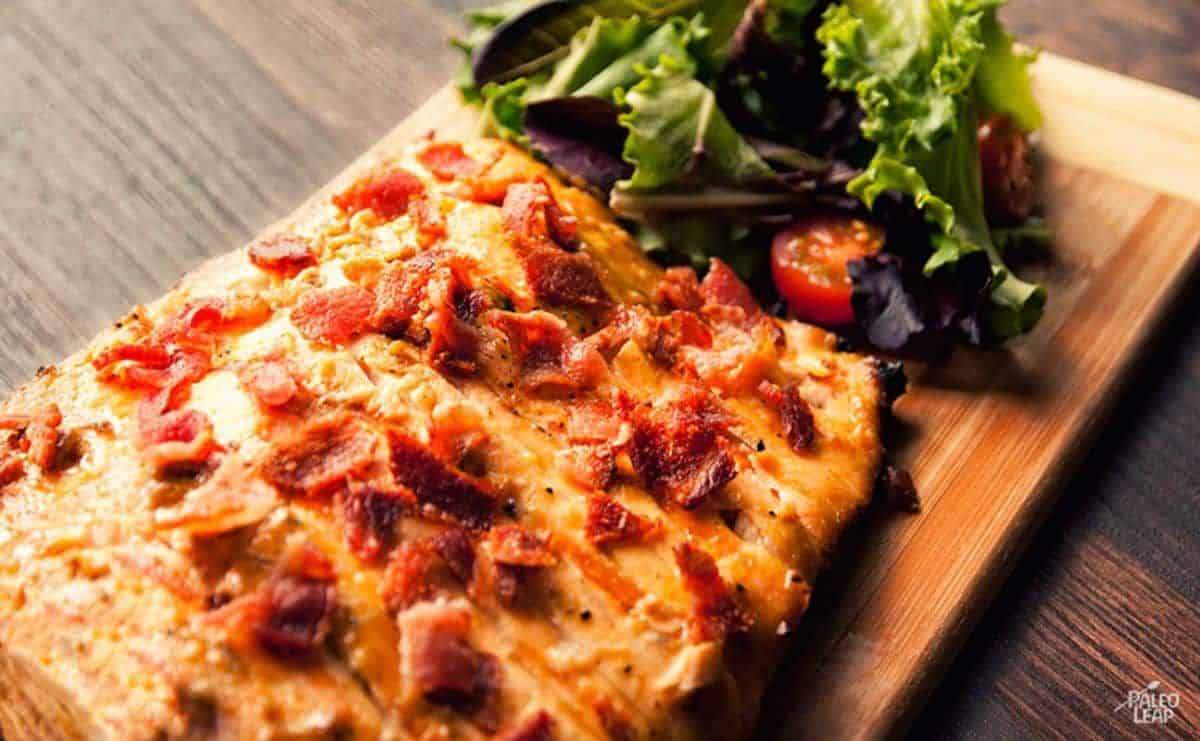 Delicious Grilled Maple Dijon Salmon with Bacon on a wooden cutting board.
