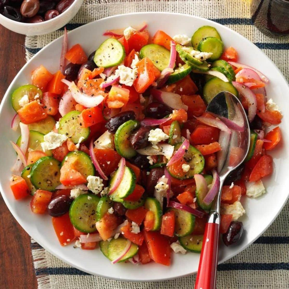 Healthy gluten-free Dad’s Greek Salad on a white plate with a spoon.