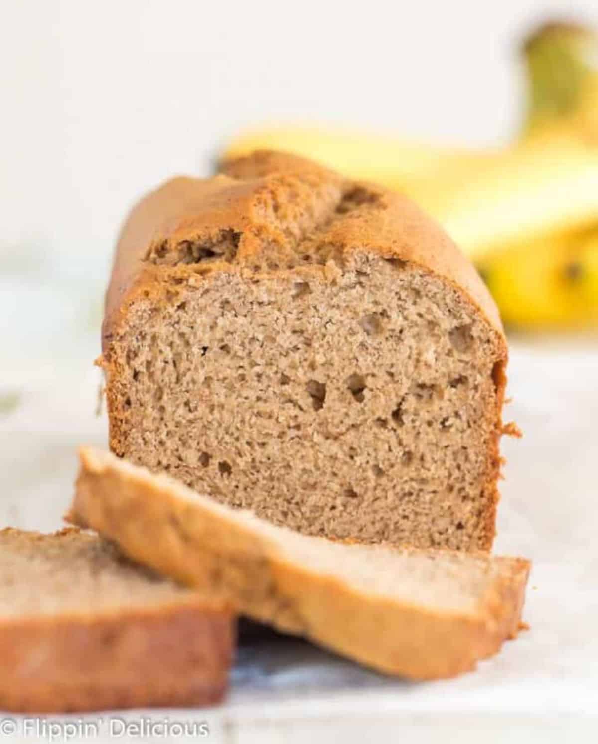 Partially sliced One Bowl Gluten-Free Banana Bread on a table.