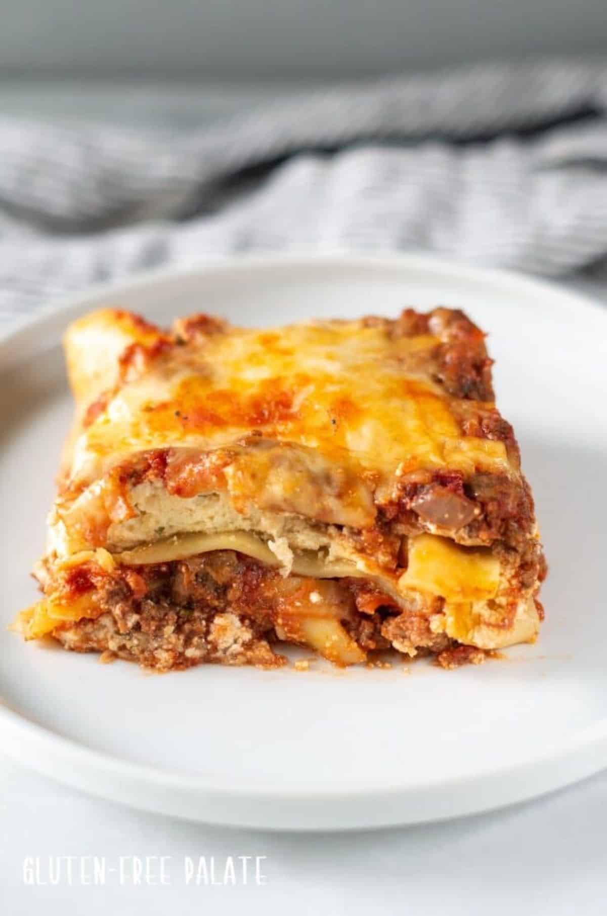A piece of juicy Gluten-Free Lasagna on a white plate.