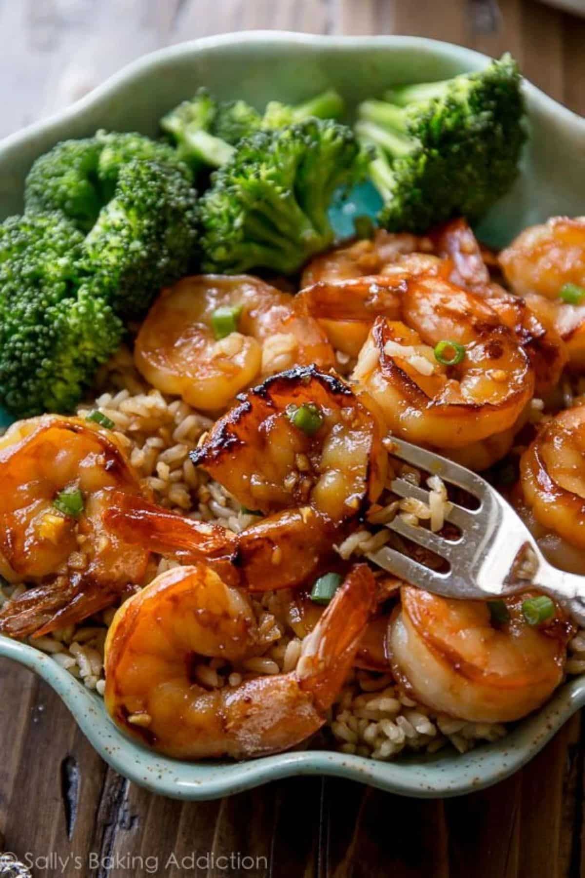 Juicy 20-Minute Honey Garlic Shrimp with rice and broccoli in a bowl with a spoon.