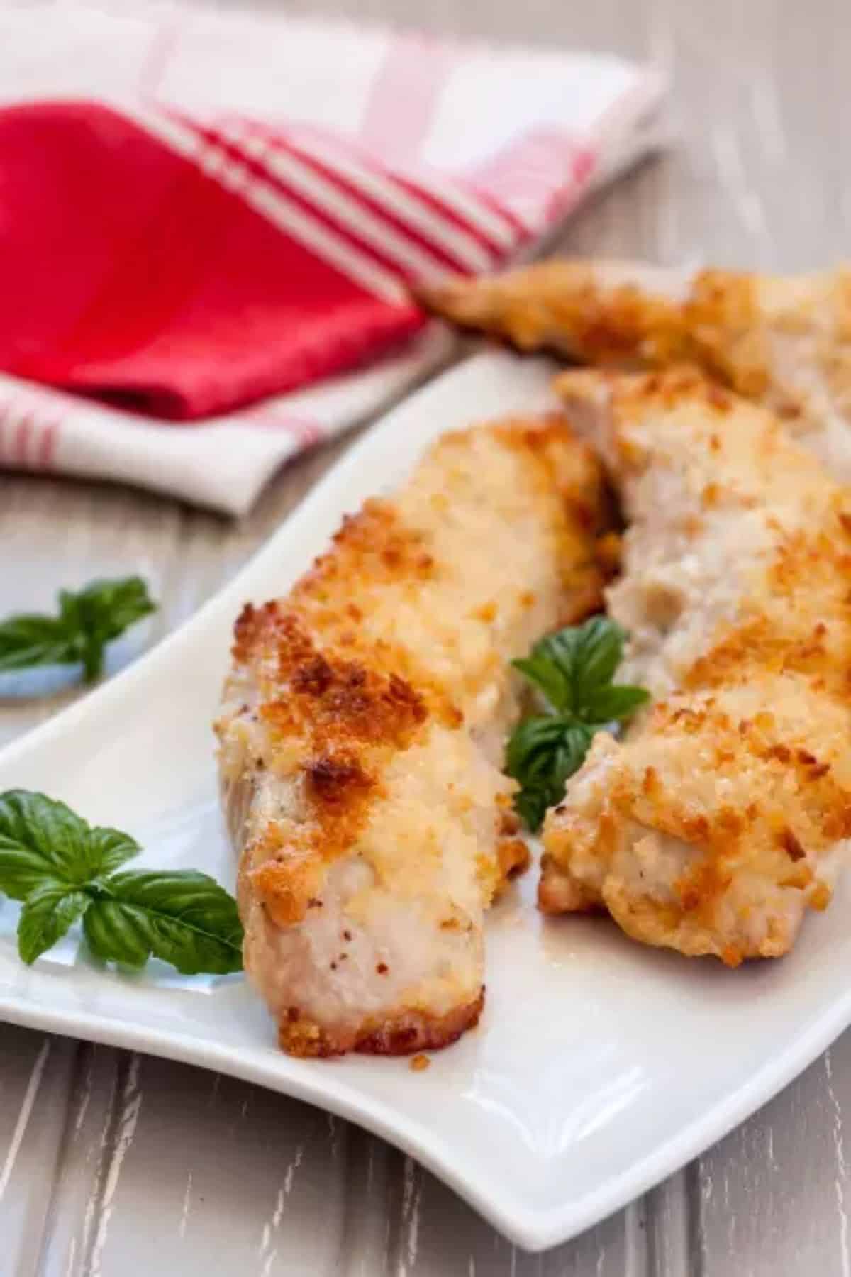 Crispy Gluten-Free Baked Chicken Parmesan on a white tray.