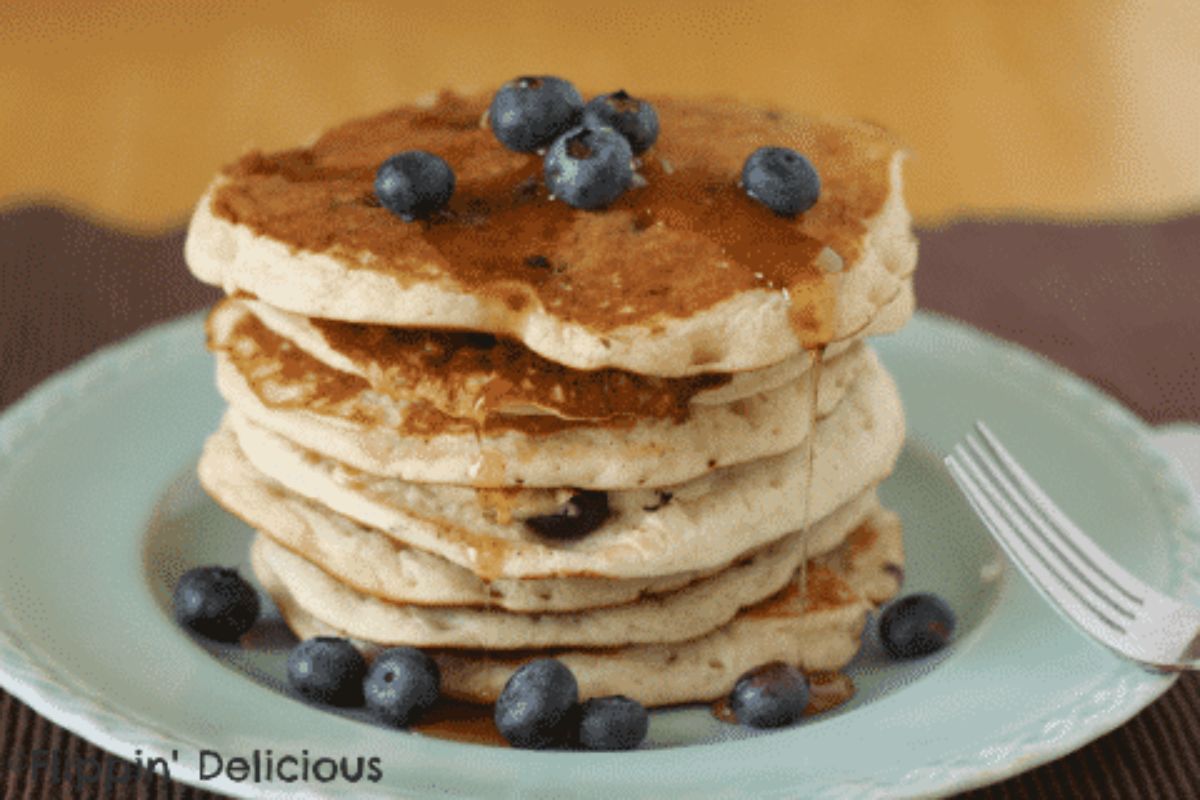 A pile of Gluten-Free Blueberry Banana Pancakes on a blue plate.