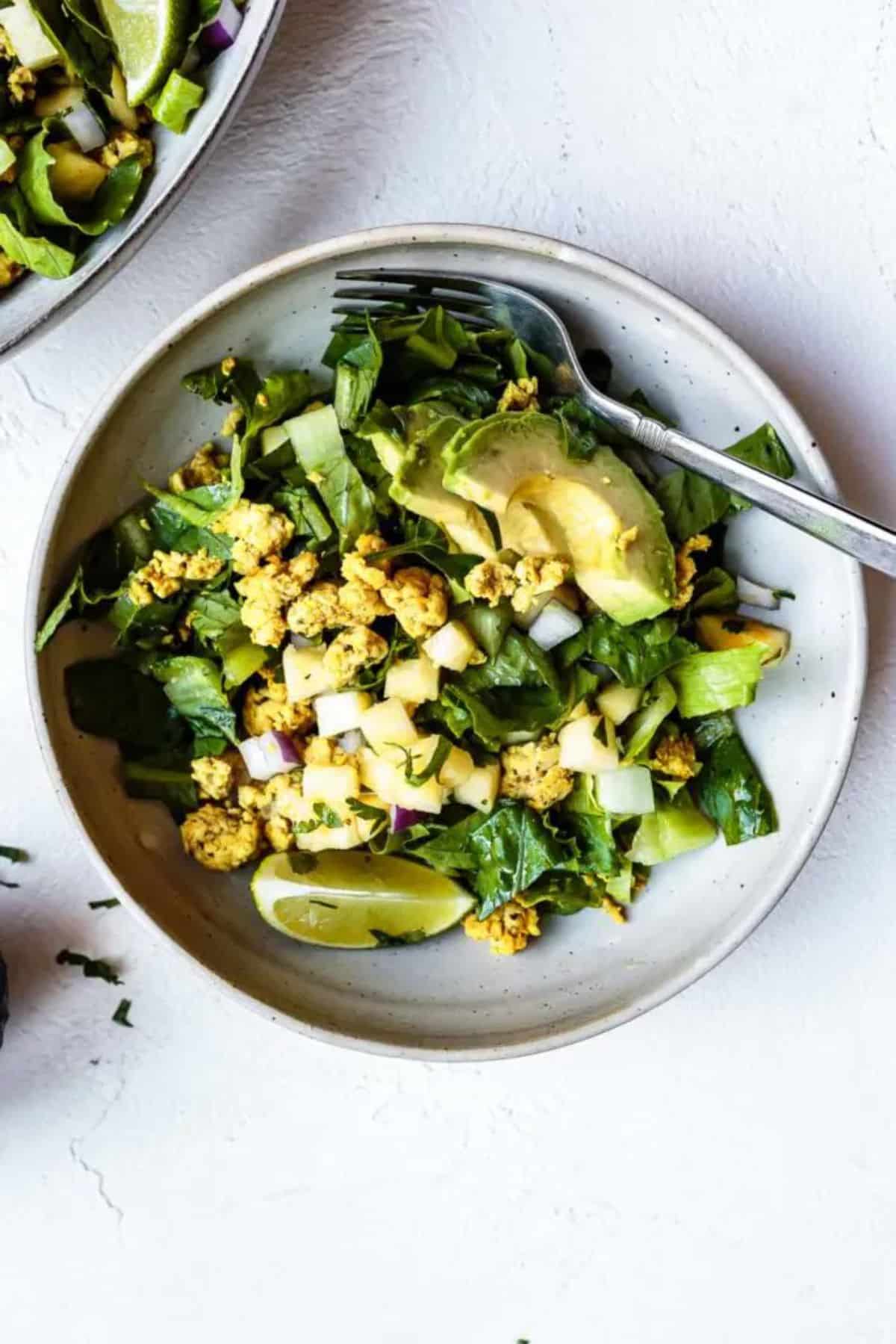 Healthy Zesty Ground Chicken Taco Salad on a gray plate with a fork.