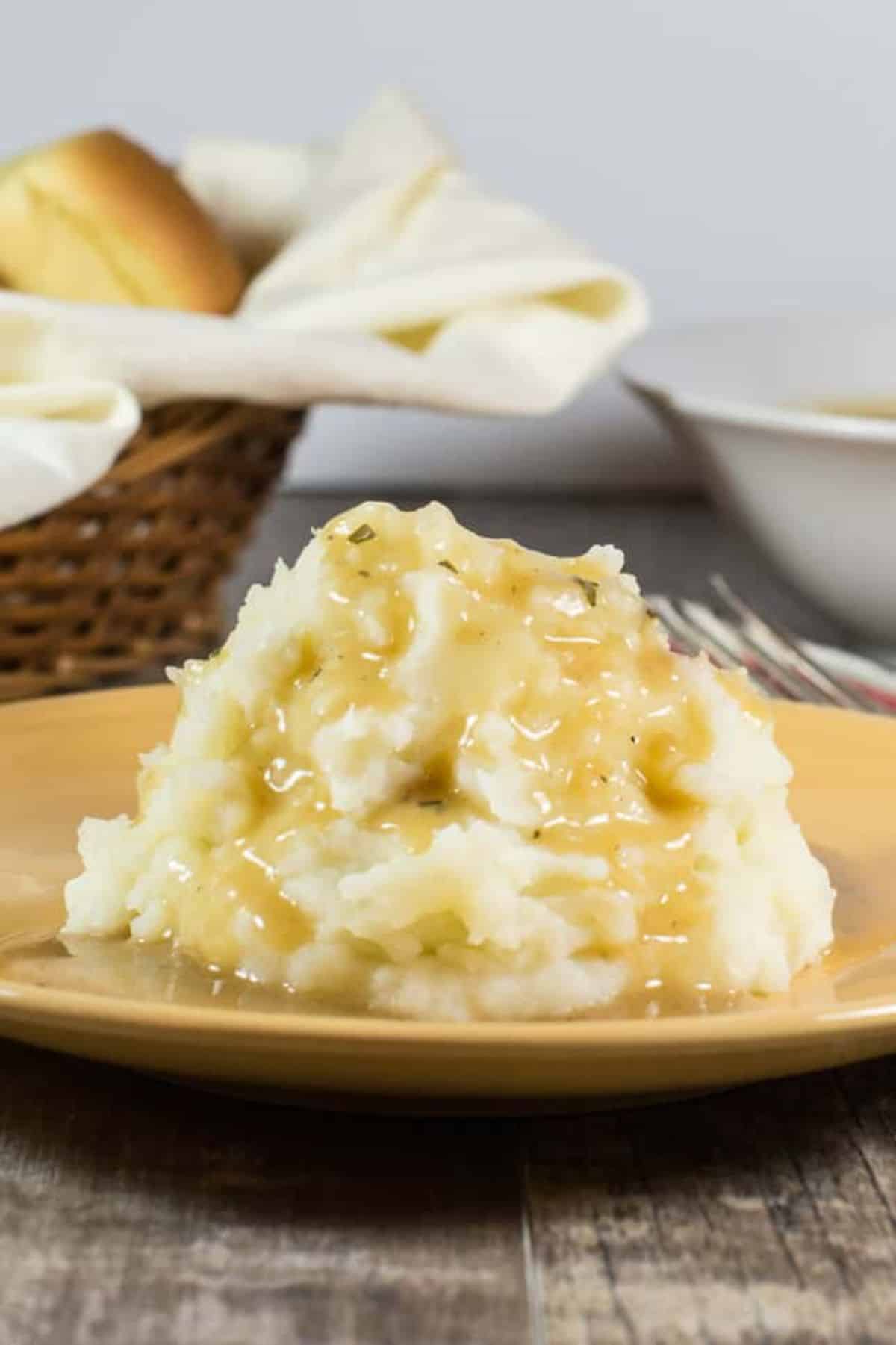 Juicy Gluten-Free & Vegetarian Savory Herb Gravy on mashed potatoes on a plate.