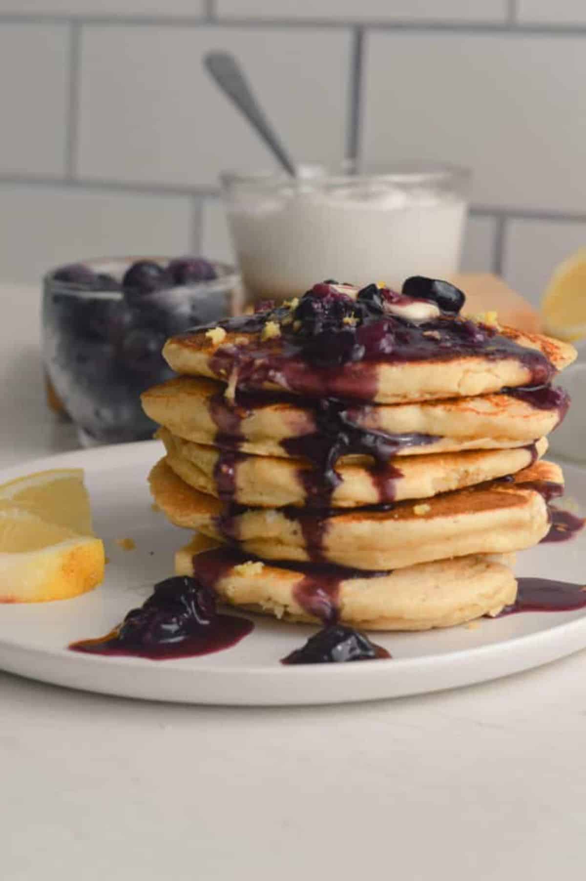 A pile of Gluten-Free Lemon Ricotta Pancakes on a white plate.