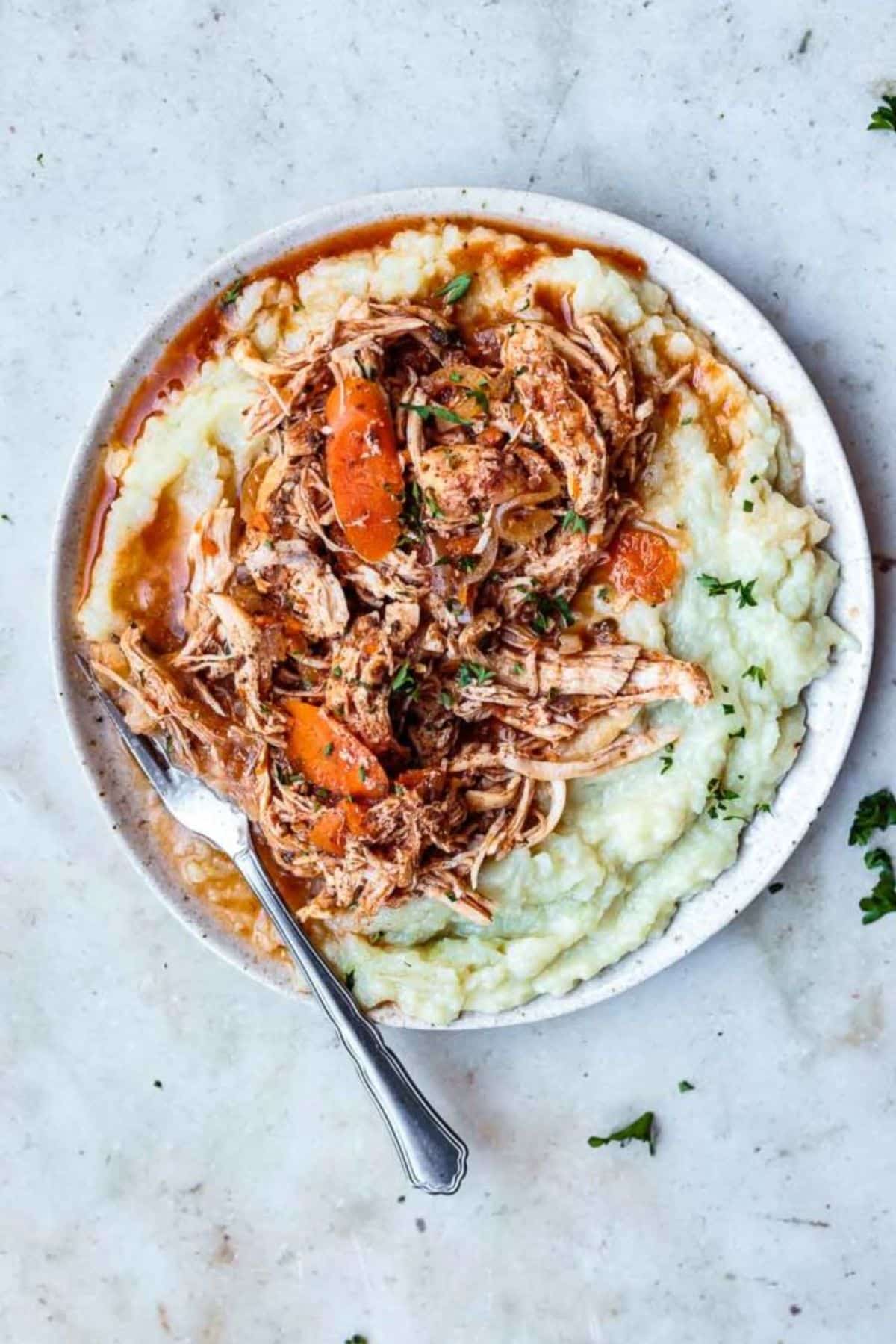 Delicious 30-Minute Greek Instant Pot Chicken Stew on a white plate with a fork.