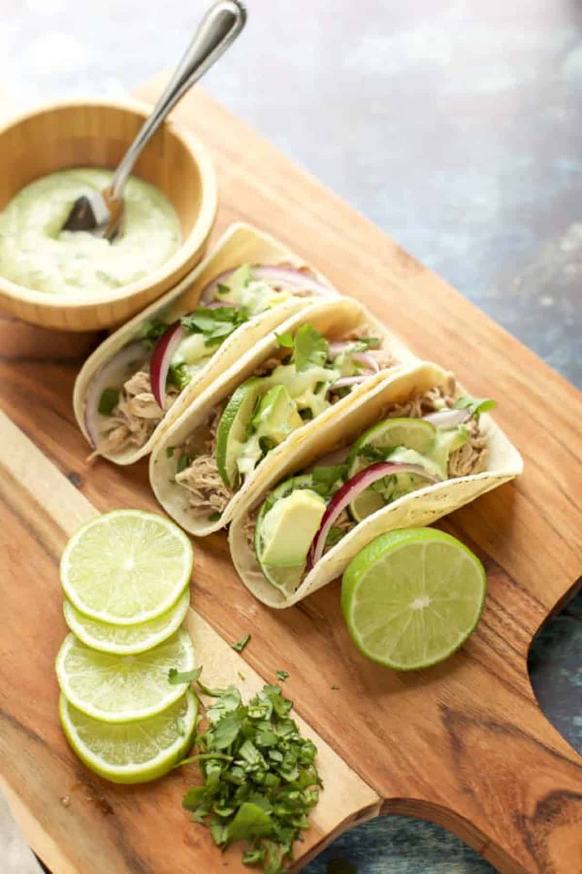 Flavorful Instant-Pot Pork Tacos on a wooden cutting board.